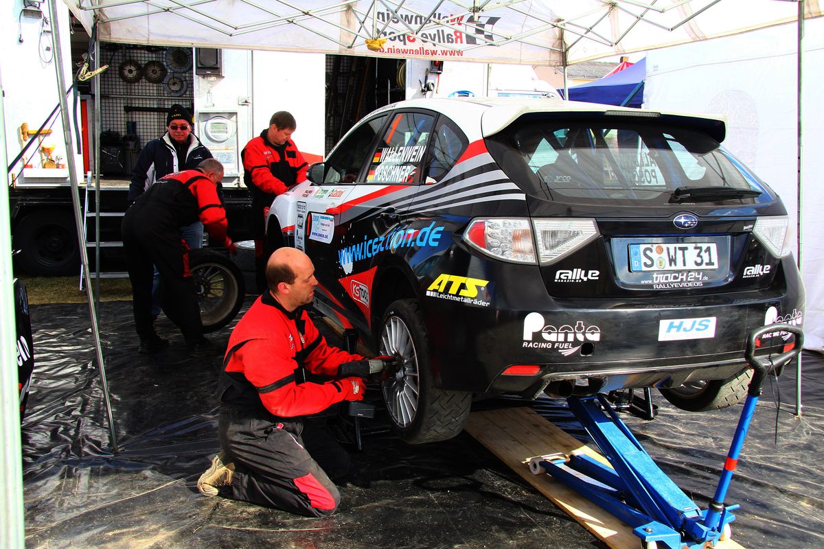 Mechaniker arbeiten am Serviceplatz einer Rallye am Fahrzeug